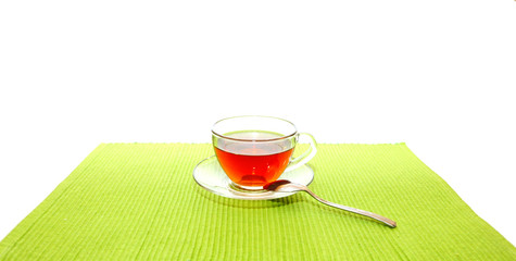 the cup of tea with spoon on the green napkin