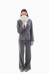 Businesswoman hiding with bank notes in her hand