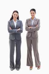 Two businesswomen smiling and crossing their arms