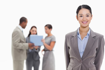 Businesswoman smiling with co-workers in the background