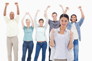 Fototapeta premium Close-up of a woman clenching her fists with people raising thei