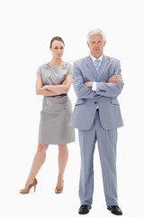 White hair businessman with a woman behind him crossing their ar