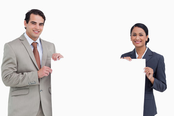 Smiling salesteam holding blank sign