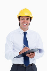 Smiling male architect with clipboard and pen