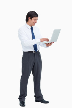 Side View Of Smiling Tradesman Working On His Laptop