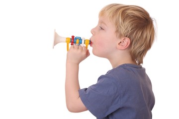 Kleiner Junge spielt auf seiner Spielzeugtrompete