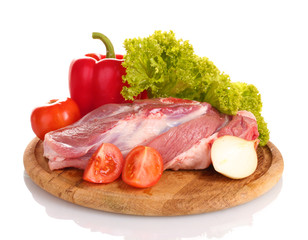 Raw meat and vegetables on a wooden board isolated on whitе