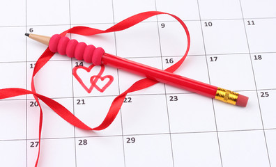 Calendar page with hearts, pencil and ribbon