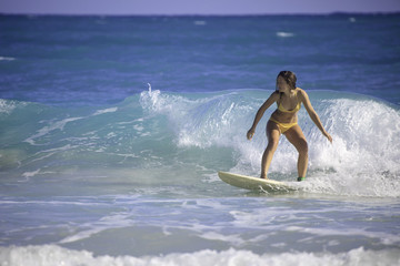 young woman surfing in hawaii