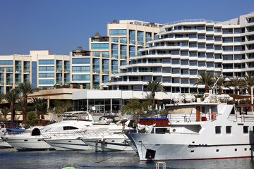 Fototapeta na wymiar Luxury Yachts Docked In Front Of Waterfront Hotels