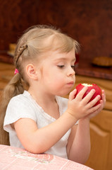 A child eats a juicy fresh apple.