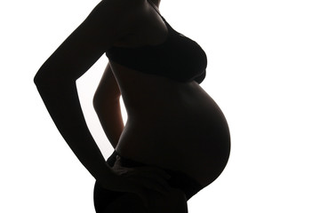 Pregnant woman in backlight white barkground