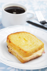 Croque-monsieur sandwich and a cup of black coffee