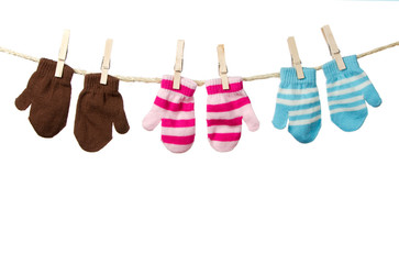 Three mittens hanging on a clothes line