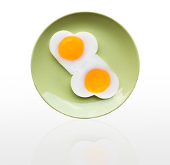 Fried egg heart on green dish