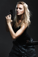 Sexy woman holding gun on gray