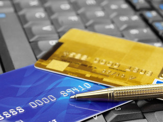 Closeup of credit cards and pen on computer keyboard