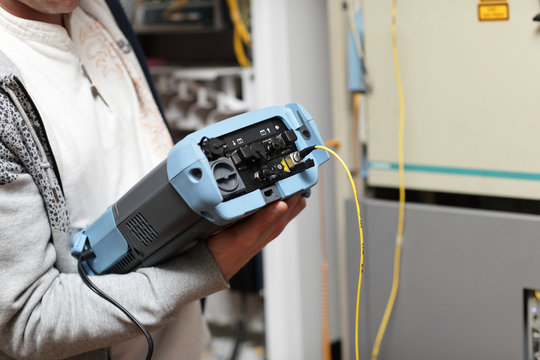 Technician with fibre optic analyser