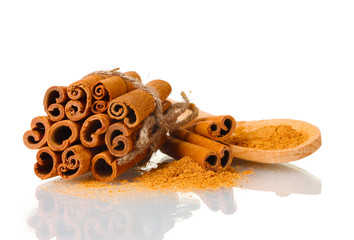 Cinnamon sticks and powder in wooden spoon isolated on white
