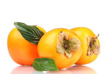 Three appetizing persimmons with green leaves isolated on white