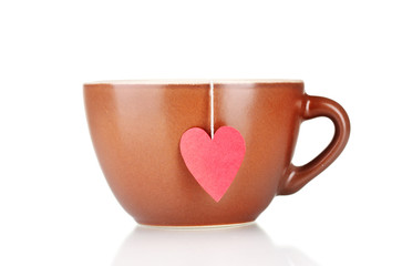 Brown cup and tea bag with red heart-shaped label isolated