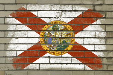 grunge flag of US state of florida on brick wall painted with ch