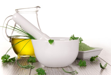 mortar with fresh herbs on wood background