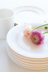 Cup and  plates with flowers on white background
