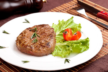 Grilled steak on a white plate