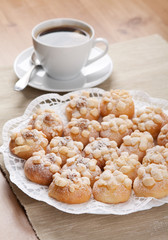 cookies sprinkled with sugar on a plate and a cup of coffee