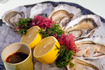 fresh oysters with  lemon on ice plate - 38506343