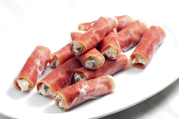 Parma ham rolls filled with cream cheese, Galia melon and capers
