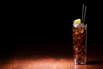 Cocktail with cola on a wooden table