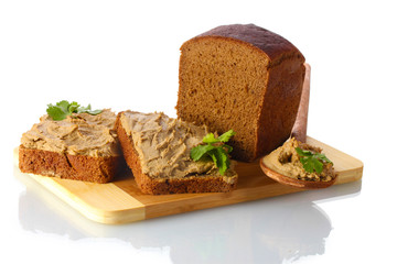Fresh pate on bread on wooden board isolated on white