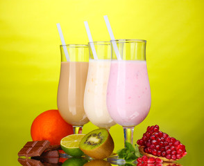 Milk shakes with fruits and chocolate on green background