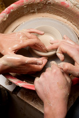 hands of a potter, creating an earthen jar on the circle