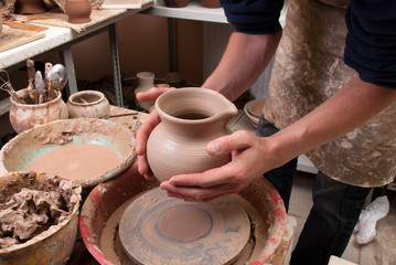 hands of a potter, creating an earthen jar on the circle