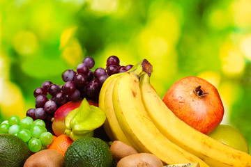 Assortment of exotic fruits on wooden table on green background