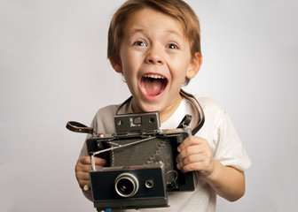 Happy photographer boy ,child ,kid taking a picture with a Polaroid style instant camera