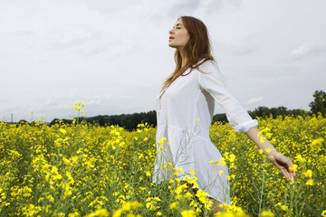 Naklejka na ściany i meble brunette woman in a yellow flowers field