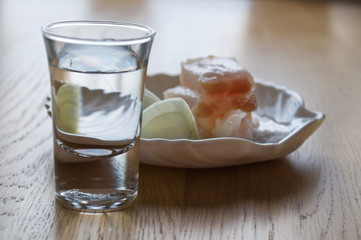 glass with vodka and a small dish of lard and onions
