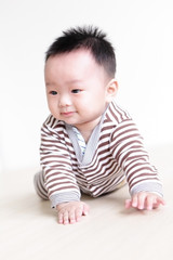 Fototapeta premium Cute Baby crawling on living room floor