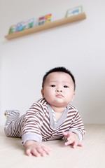Fototapeta premium Cute Baby crawling on living room floor