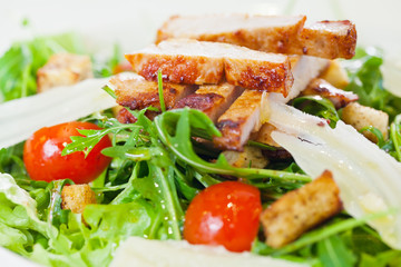 Chicken salad with tomatoes, arugula and bread croutons