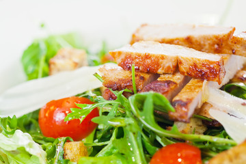 Chicken salad with tomatoes, arugula and bread croutons in the w