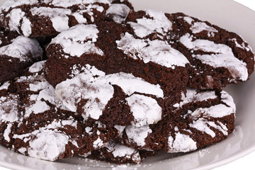 Mound of chocolate crinkle cookies against a white background