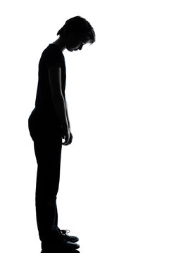 one young teenager boy or girl sad looking down silhouette