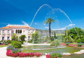 landscape with fountain, colorful flowers and blue sky
