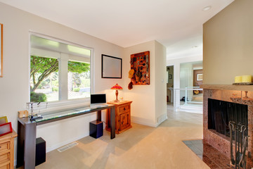 Home office with fireplace and window.with desk