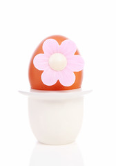 Obraz na płótnie Canvas One chicken egg with pink flower in holder